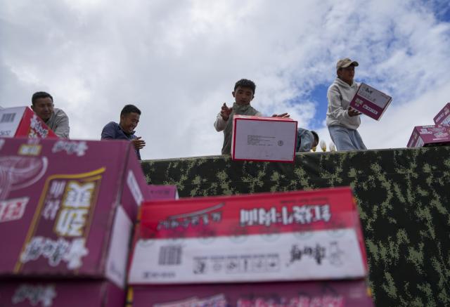 (260827) -- XIGAZE, Aug. 27, 2026 (Xinhua) -- People unload instant noodles from a vehicle in Gyirong Town of Gyirong County, Xigaze City, southwest China's Xizang Autonomous Region, Aug. 27, 2026. Six vehicles loaded with relief supplies, including instant noodles, rice, flour, mineral water and other daily necessities, arrived in Gyirong Town on Thursday afternoon. (Xinhua/Jigme Dorje)
