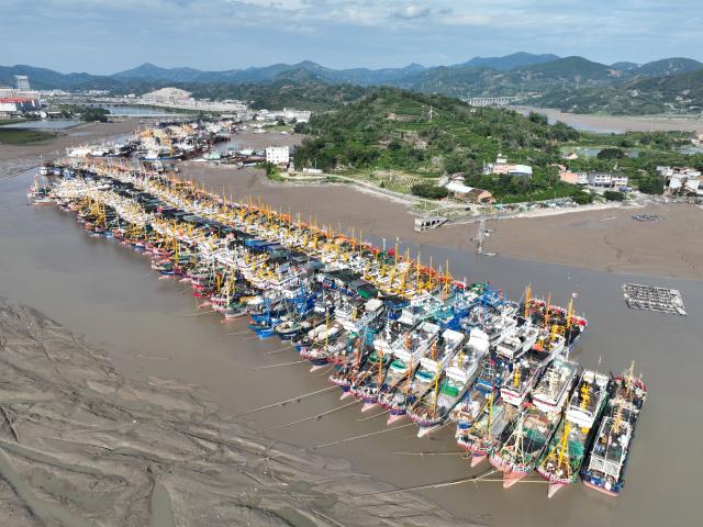 (260827) -- FUDING, Aug. 27, 2026 (Xinhua) -- An aerial drone photo taken on Aug. 27, 2026 shows fishing boats docking at Yaojiayu Pier in Kewan Village of Qianqi Town in Fuding City, southeast China's Fujian Province. Fujian raised its emergency response for typhoon damage prevention to Level II on Thursday afternoon, while keeping a Level IV flood-control emergency response.
  The local flood control authority has urged all localities and relevant departments to closely track Typhoon Saudel, the 18th typhoon of 2026, and the evolving rainfall. It called for thorough inspections in vulnerable areas and prompt evacuation of residents from high-risk zones to ensure public safety and protect property. (Xinhua/Jiang Kehong)