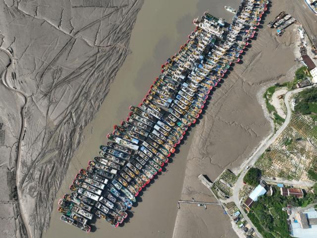 (260827) -- FUDING, Aug. 27, 2026 (Xinhua) -- An aerial drone photo taken on Aug. 27, 2026 shows fishing boats docking at Yaojiayu Pier in Kewan Village of Qianqi Town in Fuding City, southeast China's Fujian Province. Fujian raised its emergency response for typhoon damage prevention to Level II on Thursday afternoon, while keeping a Level IV flood-control emergency response.
  The local flood control authority has urged all localities and relevant departments to closely track Typhoon Saudel, the 18th typhoon of 2026, and the evolving rainfall. It called for thorough inspections in vulnerable areas and prompt evacuation of residents from high-risk zones to ensure public safety and protect property. (Xinhua/Jiang Kehong)