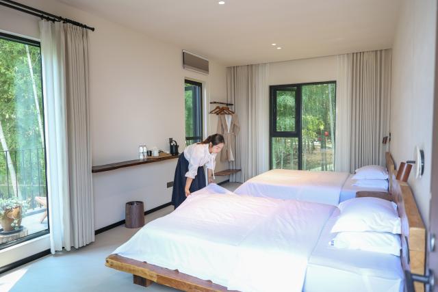 (260827) -- CHONGQING, Aug. 27, 2026 (Xinhua) -- A staff member tidies up a room at a homestay on Jinyun Mountain, Beibei District, southwest China's Chongqing, Aug. 26, 2026.
  Located along the Jialing River, Jinyun Mountain Reserve is an important ecological barrier in Chongqing and one of the best-preserved subtropical evergreen broad-leaved forest ecosystems in China. 
  Years ago, ecological conservation in the reserve was under severe strain, as unauthorized construction, irregular business activities, and unregulated expansion of farm-stay tourism ran rampant. 
  In June 2018, Chongqing launched the comprehensive ecological environment improvement project of Jinyun Mountain. 
  To date, the reserve has restored 774,000 square meters of ecology and planted about 1 million ornamental plants. The forest coverage rate has increased from 94 percent to 98 percent. 
  In 2025, the collective economic income of villages in the Jinyun Mountain area reached 27.784 million yuan (about 4.13 million U.S. dollars), and villagers' per capita annual income increased by 9.5 percent year-on-year, achieving a win-win situation for ecological protection, industrial development, and villagers' income growth. (Xinhua/Huang Wei)