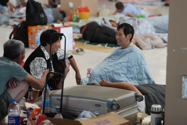 (260827) -- HANGZHOU, Aug. 27, 2026 (Xinhua) -- People rest at a resettlement site at a middle school in Yuhuan City, east China's Zhejiang Province, Aug. 27, 2026. East China's Zhejiang Province raised its typhoon emergency response to Level I, the highest level, at 8 p.m. Thursday as Typhoon Saudel, the 18th typhoon of this year, is forecast to make landfall in the province. (Xinhua/Huang Zongzhi)