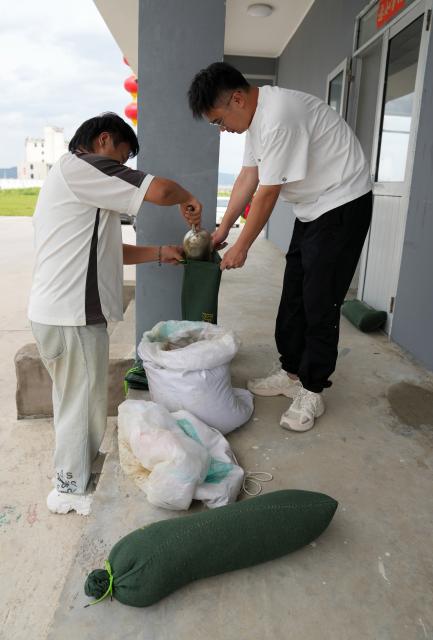 (260827) -- HANGZHOU, Aug. 27, 2026 (Xinhua) -- Staff members fill sand bags at a fishing wharf in Yueqing City, east China's Zhejiang Province, Aug. 27, 2026. East China's Zhejiang Province raised its typhoon emergency response to Level I, the highest level, at 8 p.m. Thursday as Typhoon Saudel, the 18th typhoon of this year, is forecast to make landfall in the province. (Xinhua/Han Chuanhao)