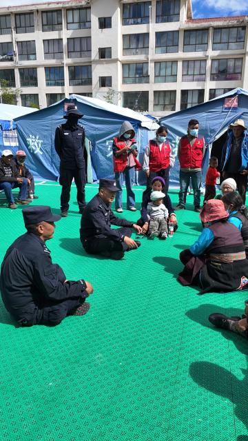 (260827) -- GYIRONG, Aug. 27, 2026 (Xinhua) -- Police officers talk to evacuated villagers at a temporary shelter in Gyirong County in Xigaze, southwest China's Xizang Autonomous Region, Aug. 27, 2026. The first batch of 26 rescue officers from the local public security authorities in Gyirong have set up 24 emergency tents in the courtyard of a township government compound and evacuated more than 320 residents affected by a mudslide in Gyirong County. (Xinhua)