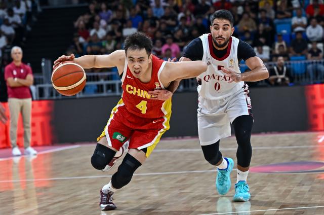 (260828) -- DOHA, Aug. 28, 2026 (Xinhua) -- Zhao Jiwei (L) of China breaks through past Moustafa Essam A A Fouda of Qatar during the second round match between China and Qatar of the FIBA World Cup Asian Qualifiers in Doha, Qatar, Aug. 27, 2026. (Photo by Nikku/Xinhua)