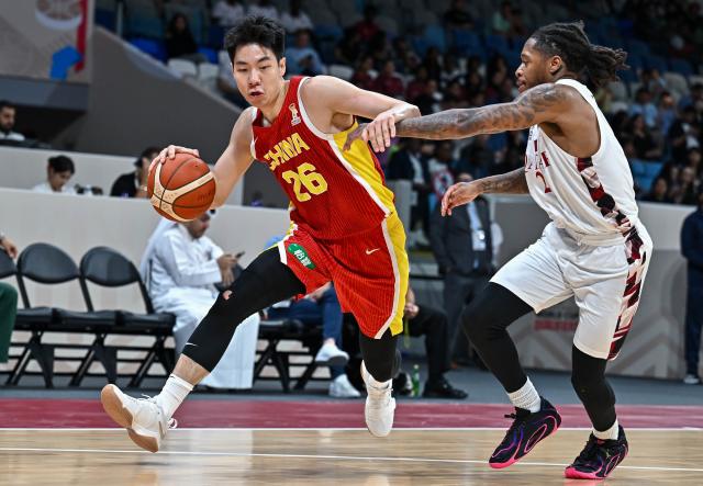 (260828) -- DOHA, Aug. 28, 2026 (Xinhua) -- Zhu Junlong (L) of China competes during the second round match between China and Qatar of the FIBA World Cup Asian Qualifiers in Doha, Qatar, Aug. 27, 2026. (Photo by Nikku/Xinhua)