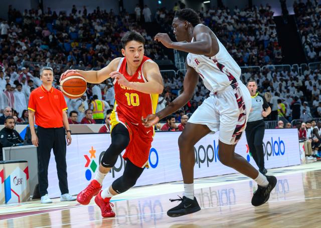 (260828) -- DOHA, Aug. 28, 2026 (Xinhua) -- Wang Junjie (L) of China competes during the second round match between China and Qatar of the FIBA World Cup Asian Qualifiers in Doha, Qatar, Aug. 27, 2026. (Photo by Nikku/Xinhua)