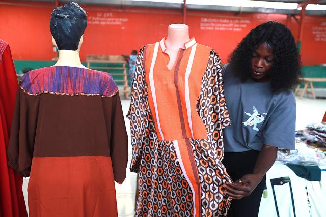(260828) -- ABIDJAN, Aug. 28, 2026 (Xinhua) -- An exhibitor adjusts a garment for display during the 7th edition of the Ivorian Traditional Fabric Days (JPTI) in Abidjan, Cote d'Ivoire, Aug. 27, 2026.
  The three-day event, held from Aug. 27 to 29, brings together artisans, weavers, fashion designers, creators and industry experts to discuss the development of the traditional fabric sector.
   Ivorian traditional fabrics feature rich patterns and distinctive designs. They are used not only to make traditional clothing, but also in modern products such as bags, serving as a link between traditional culture and contemporary life. (Photo by Yvan Sonh/Xinhua)