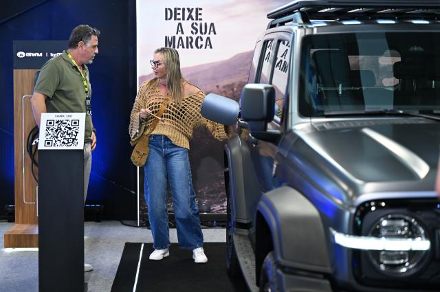 (260828) -- SAO PAULO, Aug. 28, 2026 (Xinhua) -- A visitor learns about a new energy vehicle of Chinese automaker GWM at the auto edition of the Festival Interlagos 2026 in Sao Paulo, Brazil, Aug. 27, 2026.
  The four-day auto edition of the Festival Interlagos 2026 kicked off on Thursday at the Autodromo Jose Carlos Pace in Sao Paulo. Chinese carmakers showcase their new models of new energy vehicles at the event. (Xinhua/Jin Haoyuan)