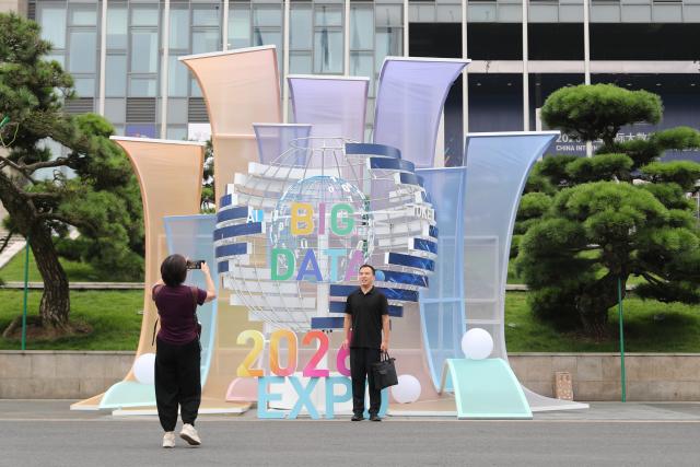 (260828) -- GUIYANG, Aug. 28, 2026 (Xinhua) -- A visitor poses for a photo in front of a logo of the 2026 China International Big Data Industry Expo in Guiyang, southwest China's Guizhou Province, Aug. 28, 2026. The 2026 China International Big Data Industry Expo opened on Friday.
   Themed "Token: A New Path to Value of Data Elements," the expo has attracted 372 domestic and international companies and over 16,000 registered guests. (Xinhua/Li Xulun)