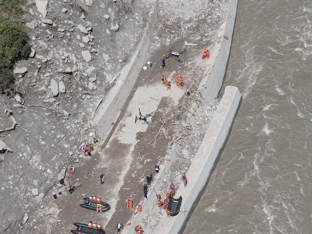 (260828) -- GYIRONG, Aug. 28, 2026 (Xinhua) -- An aerial photo taken on Aug. 28, 2026 shows rescuers using large drones to transfer supplies at the mudslide-hit areas in Gyirong, southwest China's Xizang Autonomous Region. Rescuers and engineering machines are operating around the clock to repair the mudslide-damaged road that leads to the Gyirong Port. (Xinhua/Jiang Fan)