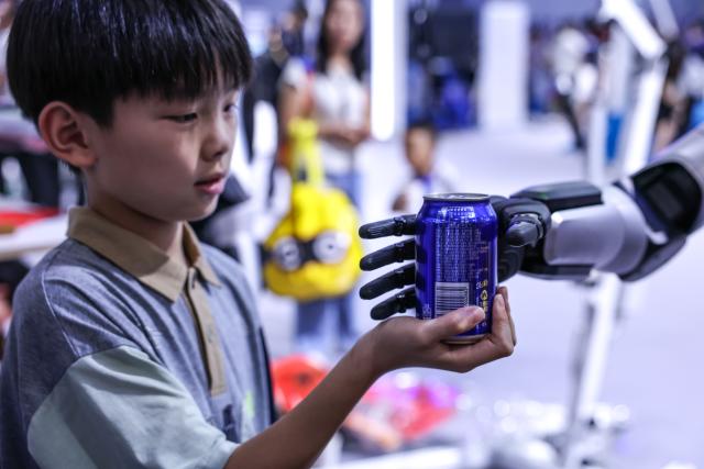 (260828) -- GUIYANG, Aug. 28, 2026 (Xinhua) -- A child interacts with a robot during the professional exhibition of the 2026 China International Big Data Industry Expo in Guiyang, southwest China's Guizhou Province, Aug. 28, 2026. Themed "Token: A New Path to Value of Data Elements," the expo spotlights cutting-edge innovations integrating data with artificial intelligence. (Xinhua/Yang Wenbin)