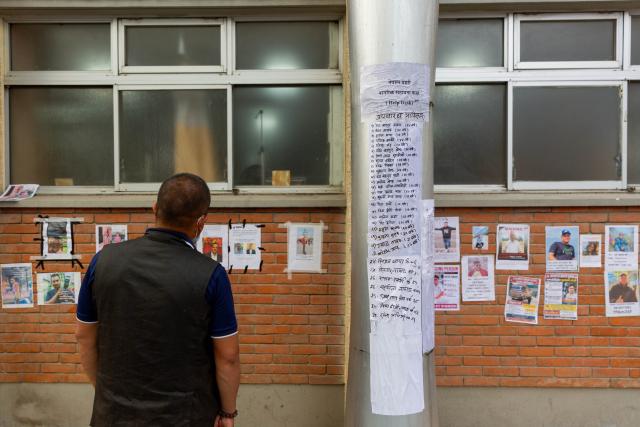 (260828) -- KATHMANDU, Aug. 28, 2026 (Xinhua) -- A man looks at photos of missing people of a massive flood outside a hospital in Kathmandu, Nepal, on Aug. 28, 2026. The National Disaster Risk Reduction and Management Authority said 579 bodies have been recovered, while 1,924 people are out of contact as of Friday evening. (Photo by Sulav Shrestha/Xinhua)