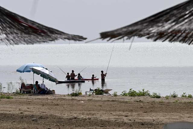 (260828) -- RESEN, Aug. 28, 2026 (Xinhua) -- People enjoy themselves at the shore of Prespa Lake, Resen, North Macedonia, Aug. 28, 2026. Temperatures soar as a heatwave grips the region, with hot summer conditions prevailing across the area. (Photo by Tomislav Georgiev/Xinhua)
