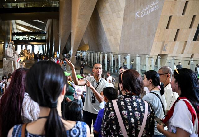 (260828) -- CAIRO, Aug. 28, 2026 (Xinhua) -- Abbas Sayed (C) gives a guided tour to visitors at the Grand Egyptian Museum in Giza, Egypt, July 2, 2026. TO GO WITH "Letter from Mideast: From strange strokes to a bridge between civilizations" (Xinhua/Xin Mengchen)