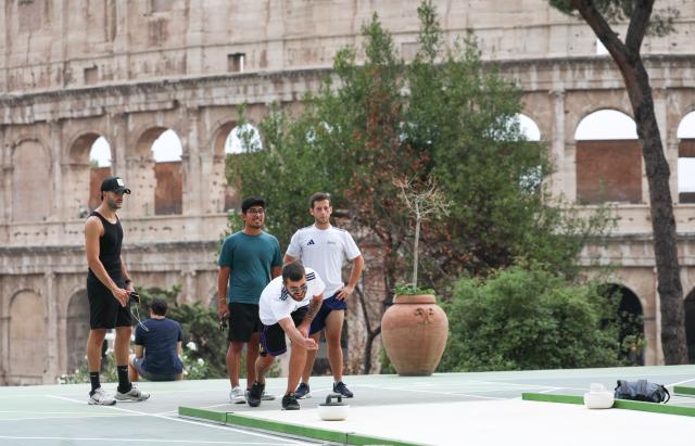 (260829) -- ROME, Aug. 29, 2026 (Xinhua) -- People try synthetic-ice curling at Colle Oppio Playground overlooking the Colosseum in Rome, Italy, Aug. 28, 2026. (Xinhua/Wang Kaiyan)