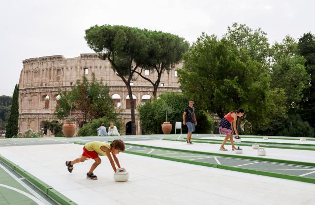 (260829) -- ROME, Aug. 29, 2026 (Xinhua) -- People try synthetic-ice curling at Colle Oppio Playground overlooking the Colosseum in Rome, Italy, Aug. 28, 2026. (Xinhua/Wang Kaiyan)