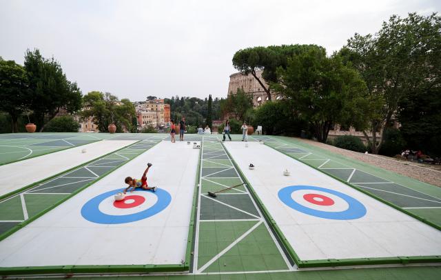 (260829) -- ROME, Aug. 29, 2026 (Xinhua) -- People try synthetic-ice curling at Colle Oppio Playground overlooking the Colosseum in Rome, Italy, Aug. 28, 2026. (Xinhua/Wang Kaiyan)
