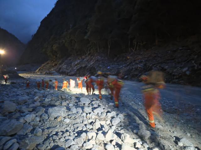 (260829) -- GYIRONG, Aug. 29, 2026 (Xinhua) -- Rescuers carry emergency rescue supplies in southwest China's Xizang Autonomous Region, on Aug. 29, 2026. More than 90 sets of emergency rescue supplies were delivered by heavy-lift drones early Saturday morning to rescue teams heading for the mudslide-hit Gyirong Port in Xizang. (Xizang Fire and Rescue Corps/Handout via Xinhua)