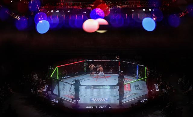 (260829) -- SHANGHAI, Aug. 29, 2026 (Xinhua) -- This multi-exposure photo shows Sean Woodson of the United States competes against Jack Jenkins of Australia during the UFC Fight Night Featherweight Bout 3 Rounds at the Oriental Sports Center in east China's Shanghai, Aug. 29, 2026. (Xinhua/Li Ming)