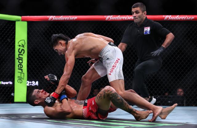 (260829) -- SHANGHAI, Aug. 29, 2026 (Xinhua) -- Bilal Hasan (C) of Indonesia competes against Nilson Rojas of Chile during the UFC Fight Night Flyweight Bout 3 Rounds at the Oriental Sports Center in east China's Shanghai, Aug. 29, 2026. (Xinhua/Li Ming)