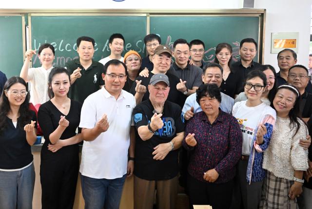 (260829) -- LUOYANG, Aug. 29, 2026 (Xinhua) -- Retired U.S. teacher Ronald Sakolsky (4th L, front) poses for a group photo with students and faculty members at Luoyang Foreign Language School in Luoyang, central China's Henan Province, Aug. 29, 2026. Sakolsky, who once supported China's desertification control efforts, on Saturday visited the school where he used to teach in Luoyang. (Xinhua/Li Jianan)