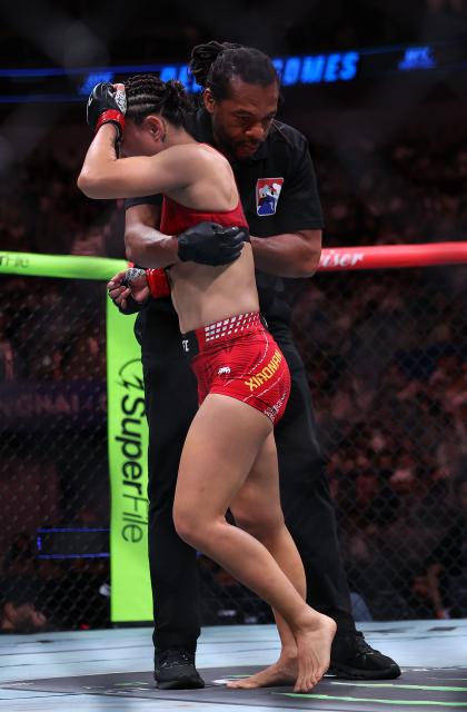 (260829) -- SHANGHAI, Aug. 29, 2026 (Xinhua) -- Yan Xiaonan (L) of China reacts after losing to Denise Gomes of Brazil during the UFC Fight Night Women's Strawweight Bout 3 Rounds at the Oriental Sports Center in east China's Shanghai, Aug. 29, 2026. (Xinhua/Li Ming)