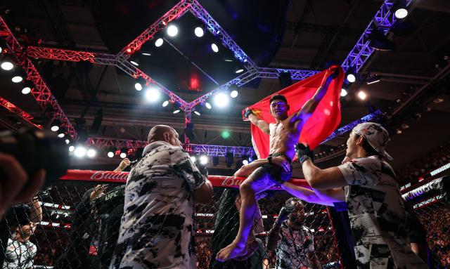 (260829) -- SHANGHAI, Aug. 29, 2026 (Xinhua) -- Song Yadong (top) of China celebrates after winng the UFC Fight Night Bantamweight Bout (Main Event) 5 Rounds against Umar Nurmagomedov of Russia at the Oriental Sports Center in east China's Shanghai, Aug. 29, 2026. (Xinhua/Li Ming)