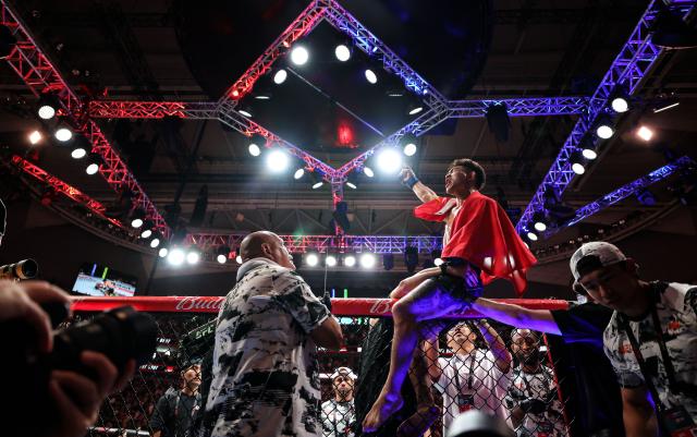 (260829) -- SHANGHAI, Aug. 29, 2026 (Xinhua) -- Song Yadong (top) of China celebrates after winng the UFC Fight Night Bantamweight Bout (Main Event) 5 Rounds against Umar Nurmagomedov of Russia at the Oriental Sports Center in east China's Shanghai, Aug. 29, 2026. (Xinhua/Li Ming)