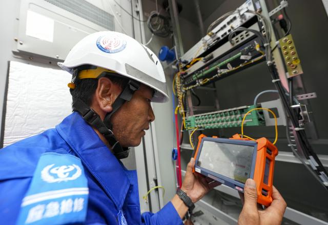 (260829) -- GYIRONG, Aug. 29, 2026 (Xinhua) -- A staff member tests fiber-optic cables in Gyirong Town, southwest China's Xizang Autonomous Region, Aug. 29, 2026. The telecommunication sector has been making all-out efforts to restore the communication infrastructure affected by the mudslide in Gyirong, and to ensure unimpeded emergency communications. So far, one base station has been restored, and 3 new base stations have been built. (Xinhua/Jigme Dorje)