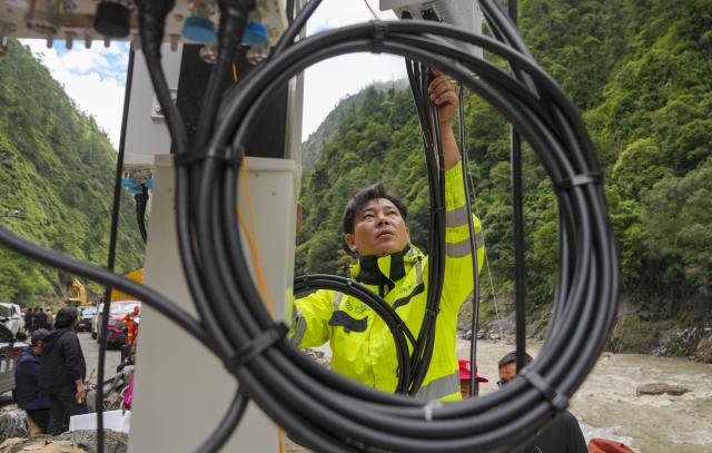 (260829) -- GYIRONG, Aug. 29, 2026 (Xinhua) -- A staff member works on a base station in Gyirong Town, southwest China's Xizang Autonomous Region, Aug. 29, 2026. The telecommunication sector has been making all-out efforts to restore the communication infrastructure affected by the mudslide in Gyirong, and to ensure unimpeded emergency communications. So far, one base station has been restored, and 3 new base stations have been built. (Xinhua/Jigme Dorje)