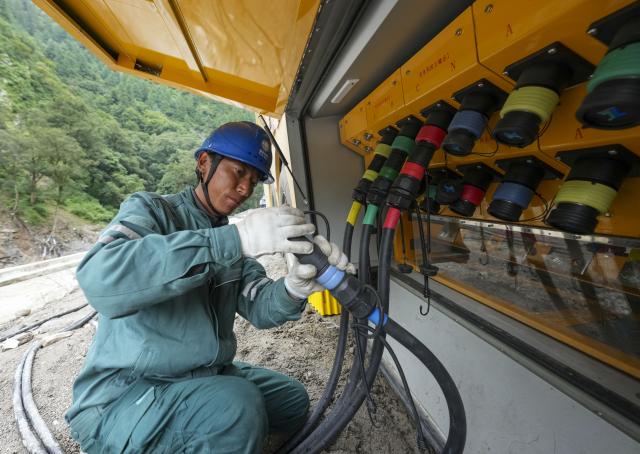 (260830) -- LHASA, Aug. 30, 2026 (Xinhua) -- A staff member connects low-voltage output cables near the mudslide-hit Gyirong Port, in Gyirong County, southwest China's Xizang Autonomous Region, Aug. 29, 2026. A total of 2,141 rescuer personnel, 269 rescue vehicles and 3,922 sets of equipments have been deployed to the mudslide-hit areas so far to search for the missing, with rescue teams searching an area of about 90,000 square meters. (Xinhua/Jigme Dorje)