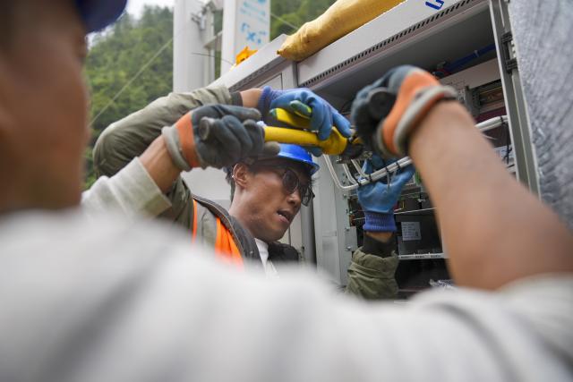(260830) -- LHASA, Aug. 30, 2026 (Xinhua) -- Staff members work on a signal base station in Gyirong Town, southwest China's Xizang Autonomous Region, Aug. 29, 2026. A total of 2,141 rescuer personnel, 269 rescue vehicles and 3,922 sets of equipments have been deployed to the mudslide-hit areas so far to search for the missing, with rescue teams searching an area of about 90,000 square meters. (Xinhua/Jigme Dorje)