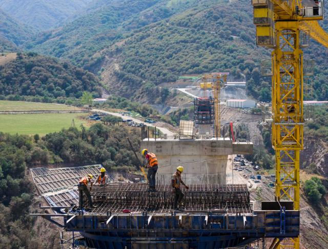 (260830) -- BISHKEK, Aug. 30, 2026 (Xinhua) -- A drone photo taken on Aug. 15, 2026 shows workers at a construction site of a grand bridge above the Kec-Alat River along the China-Kyrgyzstan-Uzbekistan railway in Jalalabad, Kyrgyzstan. The China-Kyrgyzstan-Uzbekistan railway is a flagship project of the Belt and Road Initiative, personally promoted by the heads of state of China, Kyrgyzstan and Uzbekistan.
  The route begins in Kashgar, located in northwest China's Xinjiang Uygur Autonomous Region, and passes through the mountainous terrain of Kyrgyzstan to reach Uzbekistan.
  It has become a strategic corridor benefiting all the three countries and their peoples, contributing to regional economic and social development and playing a significant role in promoting infrastructure connectivity, economic and trade exchanges, and high-quality development of the Belt and Road. (Xinhua/Li Renzi)