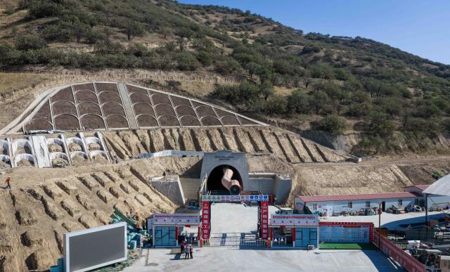 (260830) -- BISHKEK, Aug. 30, 2026 (Xinhua) -- An aerial drone photo taken on Aug. 15, 2026 shows the construction site of the Jalalabad tunnel of the China-Kyrgyzstan-Uzbekistan railway in Jalalabad, Kyrgyzstan. The China-Kyrgyzstan-Uzbekistan railway is a flagship project of the Belt and Road Initiative, personally promoted by the heads of state of China, Kyrgyzstan and Uzbekistan.
  The route begins in Kashgar, located in northwest China's Xinjiang Uygur Autonomous Region, and passes through the mountainous terrain of Kyrgyzstan to reach Uzbekistan.
  It has become a strategic corridor benefiting all the three countries and their peoples, contributing to regional economic and social development and playing a significant role in promoting infrastructure connectivity, economic and trade exchanges, and high-quality development of the Belt and Road. (Xinhua/Li Renzi)