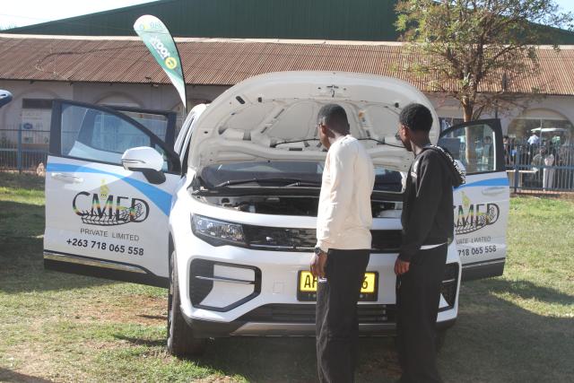 (260830) -- HARARE, Aug. 30, 2026 (Xinhua) -- Visitors look at an electric vehicle on display at the Zimbabwe Agricultural Show in Harare, Zimbabwe, Aug. 28, 2026. TO GO WITH "Zimbabwe's e-mobility drive gains traction with Chinese EVs" (Photo by Tafara Mugwara/Xinhua)