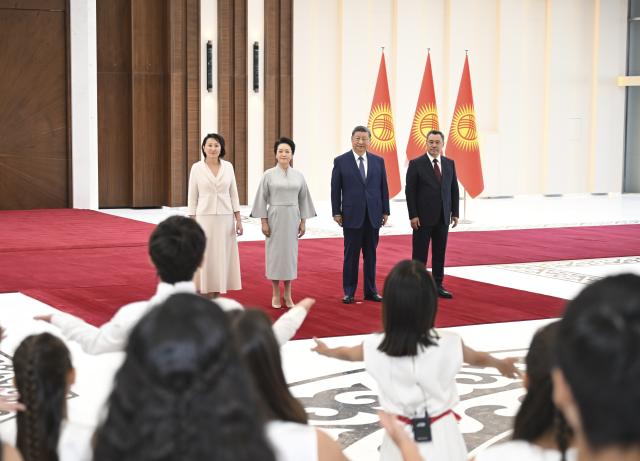 (260830) -- BISHKEK, Aug. 30, 2026 (Xinhua) -- Chinese President Xi Jinping and his wife Peng Liyuan, together with Kyrgyz President Sadyr Japarov and his wife Aigul Japarova, jointly appreciate Chinese songs singing by local teenagers in Bishkek, Kyrgyzstan, Aug. 30, 2026. Xi landed in Bishkek on Sunday for the Shanghai Cooperation Organization (SCO) Summit 2026 and a state visit to Kyrgyzstan upon the invitation of Japarov.
   Upon the arrival, Japarov and his wife Aigul Japarova welcomed Xi and his wife, Peng Liyuan, at the Manas International Airport. (Xinhua/Yan Yan)