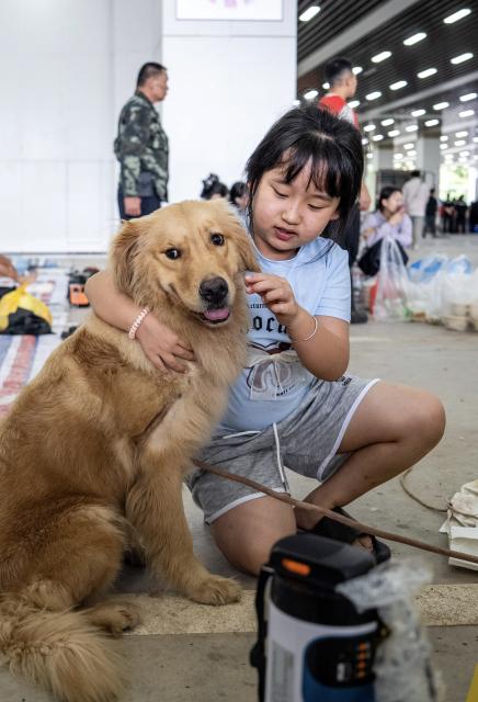 (260830) -- MOHAN, Aug. 30, 2026 (Xinhua) -- A girl plays with his pet dog at a temporary shelter in Mohan Town, southwest China's Yunnan Province, Aug. 30, 2026.
  Heavy rainfall has triggered severe flooding in Mohan Town in southwest China's Yunnan Province, with a reservoir at risk of breaching, authorities said Saturday.
  Altogether 8,115 residents have been evacuated in emergency by Sunday, and relief items are dispatched to relocations sites to meet people's necessities. (Xinhua/Hu Chao)