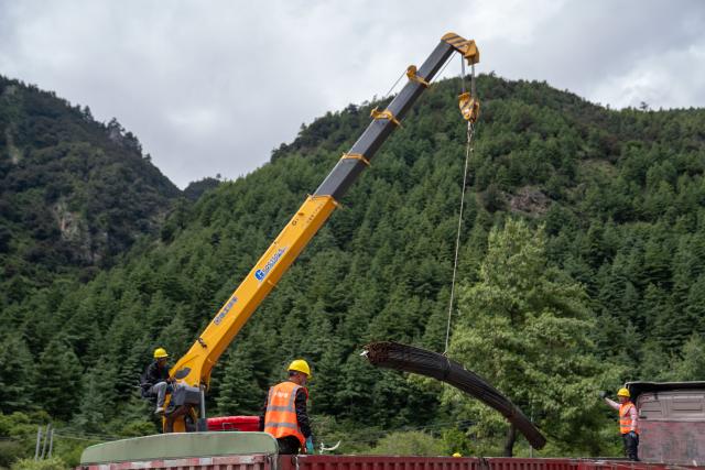 (260830) -- GYIRONG, Aug. 30, 2026 (Xinhua) -- Workers from China Railway Group Limited unload steel bars at a temporary processing site in Gyirong County, southwest China's Xizang Autonomous Region, Aug. 30, 2026. Workers from China Railway Group Limited stepped up efforts on Sunday to make steel-reinforced gabion baskets to support the restoration of road access to mudslide-hit areas in Gyirong County for rescue operations. (Xinhua/Jiang Fan)