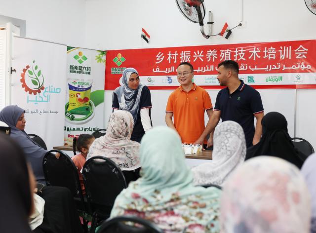 (260830) -- BEHEIRA GOVERNORATE, Aug. 30, 2026 (Xinhua) -- A Chinese employee from New Hope Alexandria Co., Ltd explains poultry-raising techniques for local farmers in Dimisna village, Beheira Governorate, Egypt, July 27, 2026. TO GO WITH "Feature: Chinese firm helps rural Egyptian women improve livelihoods through poultry raising" (Xinhua/Zhang Haobo)