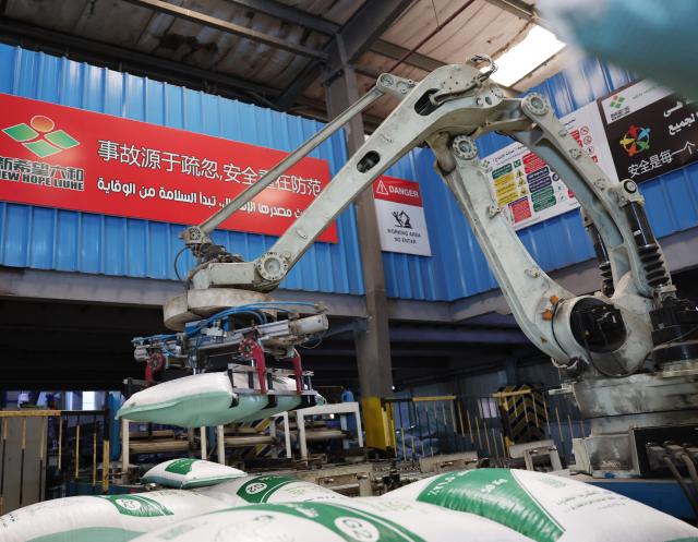 (260830) -- BEHEIRA GOVERNORATE, Aug. 30, 2026 (Xinhua) -- A robotic arm stacks bags of feed at New Hope Alexandria Co., Ltd. in Beheira Governorate, Egypt, July 27, 2026. TO GO WITH "Feature: Chinese firm helps rural Egyptian women improve livelihoods through poultry raising" (Xinhua/Zhang Haobo)