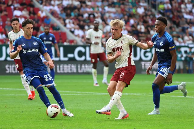 (260831) -- AUGSBURG, Aug. 31, 2026 (Xinhua) -- Hennes Behrens (C) of FC Augsburg vies with Junior Adamu (R) and Soufiane El-Faouzi of FC Schalke 04 during the German first division Bundesliga football match between FC Augsburg and FC Schalke 04 in Augsburg, Germany, Aug. 30, 2026. (Photo by Philippe Ruiz/Xinhua)