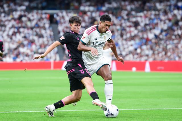 (260831) -- MADRID, Aug. 31, 2026 (Xinhua) -- Real Madrid's Jude Bellingham (R) vies Malaga's Izan Merino during a La Liga football match between Real Madrid and Malaga CF at Santiago Bernabeu stadium in Madrid, Spain, on Aug. 30, 2026. (Photo by Gustavo Valiente/Xinhua)