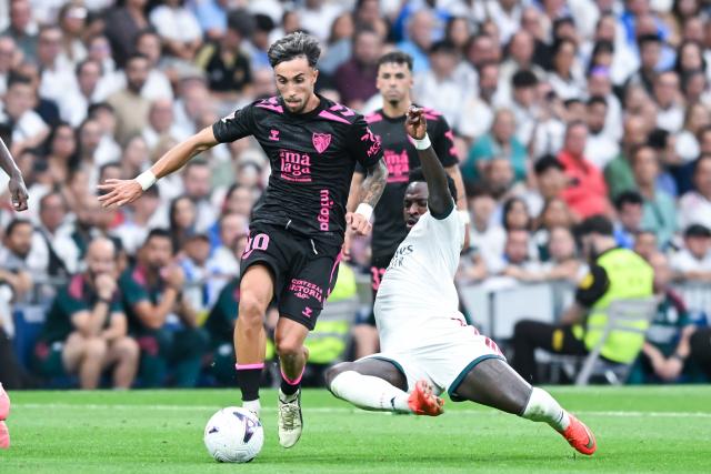 (260831) -- MADRID, Aug. 31, 2026 (Xinhua) -- Real Madrid's Vinicius Jr. (R) vies with Malaga's David Larrubia during a La Liga football match between Real Madrid and Malaga CF at Santiago Bernabeu stadium in Madrid, Spain, on Aug. 30, 2026. (Photo by Gustavo Valiente/Xinhua)