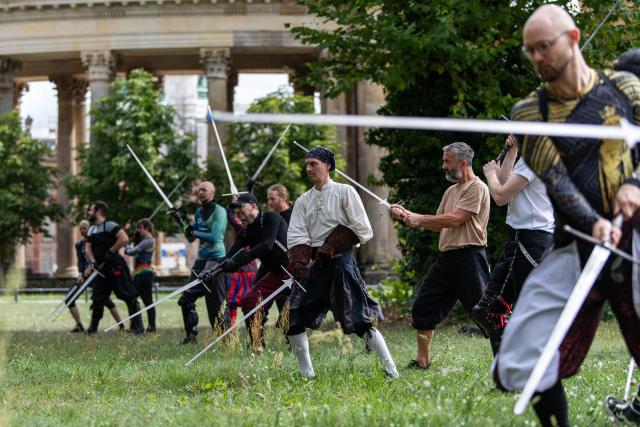 (260831) -- POTSDAM, Aug. 31, 2026 (Xinhua) -- Enthusiasts practice swordsmanship together at Sanssouci Park in Potsdam, Germany, Aug. 30, 2026.
  Swordsmanship enthusiasts gathered here on Sunday to practice and exchange skills in historical European swordsmanship against the backdrop of the city's iconic historic architecture. (Xinhua/Zhang Haofu)