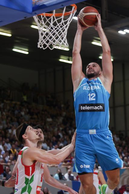 (260831) -- LJUBLJANA, Aug. 31, 2026 (Xinhua) -- Rok Radovic (top) of Slovenia goes for a dunk during the men's FIBA Basketball World Cup 2027 European Qualifiers match between Slovenia and Hungary at Tivoli Sports Hall in Ljubljana, Slovenia, Aug. 30, 2026. (Photo by Zeljko Stevanic/Xinhua)