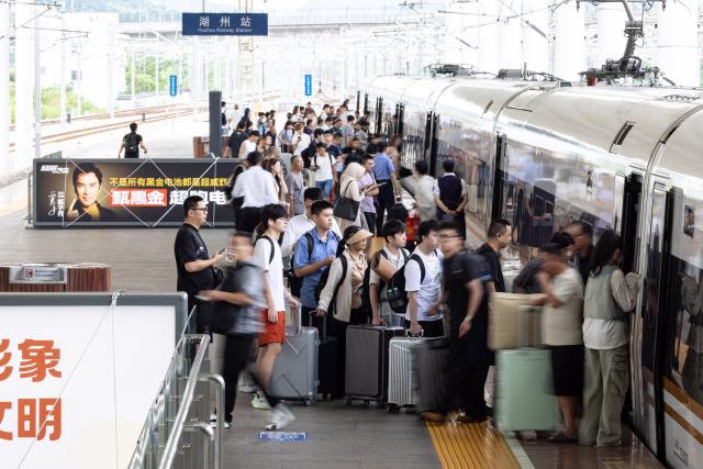 (260831) -- BEIJING, Aug. 31, 2026 (Xinhua) -- Passengers board a train at Huzhou Railway Station in Huzhou, east China's Zhejiang Province, Aug. 31, 2026. The 62-day summer travel rush officially concluded on Monday. (Photo by Yi Fan/Xinhua)