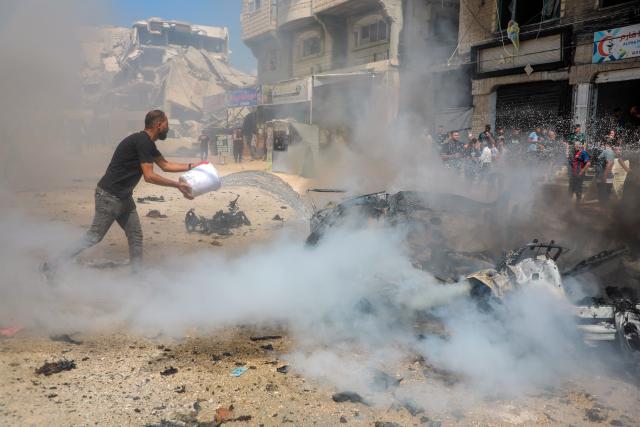 (260831) -- GAZA, Aug. 31, 2026 (Xinhua) -- A Palestinian extinguishes fire in a destroyed vehicle following an Israeli drone strike in the Tel al-Hawa neighborhood in Gaza City, Aug. 31, 2026. Three Palestinians were killed on Monday in an Israeli strike targeting a vehicle in Gaza City, according to Palestinian medical sources. (Photo by Rizek Abdeljawad/Xinhua)