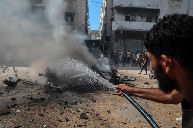 (260831) -- GAZA, Aug. 31, 2026 (Xinhua) -- A Palestinian extinguishes fire in a destroyed vehicle following an Israeli drone strike in the Tel al-Hawa neighborhood in Gaza City, Aug. 31, 2026. Three Palestinians were killed on Monday in an Israeli strike targeting a vehicle in Gaza City, according to Palestinian medical sources. (Photo by Rizek Abdeljawad/Xinhua)