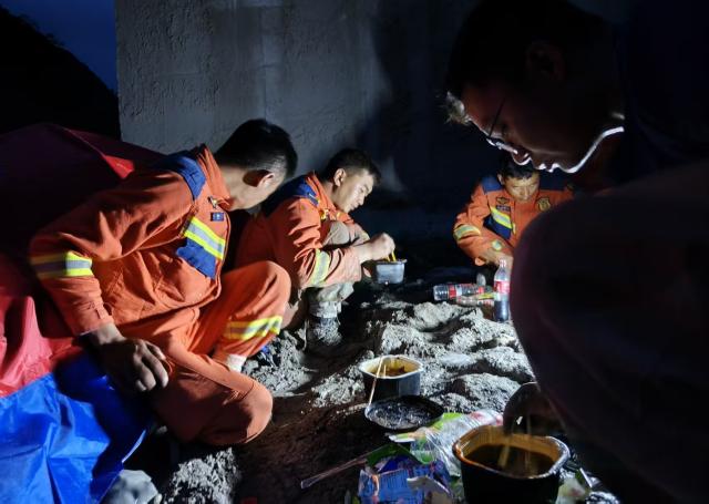 (260901) -- GYIRONG, Sept. 1, 2026 (Xinhua) -- Rescuers have their first meal of the day in Gyirong County, southwest China's Xizang Autonomous Region, Aug. 31, 2026. Despite difficulties such as high-altitude terrain, steep valleys and volatile weather, the rescue forces have been working around the clock to search for survivors, repair roads, set up communication base stations and restore power lines. (Xinhua/Jigme Dorje)