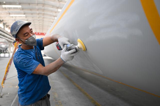 (260903) -- URUMQI, Sept. 3, 2026 (Xinhua) -- A staff member is busy at a processing workshop of wind turbine blades in a new materials company in Changji City, northwest China's Xinjiang Uygur Autonomous Region, Aug. 31, 2026.
  By leveraging its rich resources, Xinjiang has made remarkable progress in developing the new materials sector and forging new growth engines in recent years. Years of sustained effort to achieve breakthroughs in core technologies in key fields and in smart manufacturing of new materials have boosted industrial cluster formation and drive high-quality growth in the region. (Xinhua/Ding Lei)